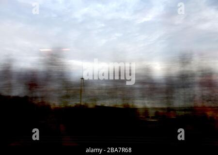 Blurry agricultural landscape; taken from high speed train with nicely lined up rows of trees with motion blur giving an abstract somewhat sinister Stock Photo