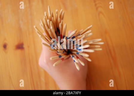 Wooden stick game in hands, playing toys - hobbies kids or adults Stock Photo