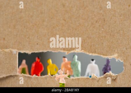 Close up view of toy near cardboard with hole and silhouettes of people figures isolated on grey, concept of social rights Stock Photo