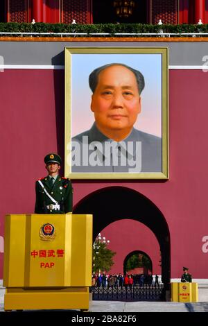 Beijing, China - October 2019; Close up of guard in front of Tiananmen gate entrance to Forbidden city with a portrait of President Mao Zedong hanging Stock Photo
