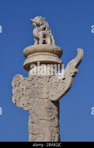 Beijing, China - October 2019; Close up view of a marble huabiao column in front of the Forbidden city in Beijing against a blue sky; on top the mythi Stock Photo