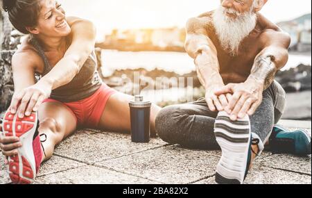 Fit couple making stretching before running workout - Joggers training outdoor at sunset together - Main focus on woman face - Fitness, sport, wellnes