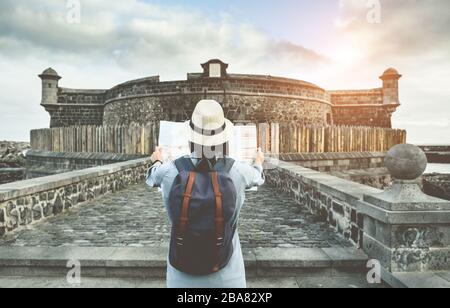 Young woman tourist looking map during city tour - Travel girl going around old town on vacation - Holiday, wanderlust and trip trends concept - Focus Stock Photo