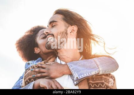 Multiracial couple having tender moments outdoor at sunset - Young lovers having fun together - Love, relationship and muti ethnic concept - Focus on