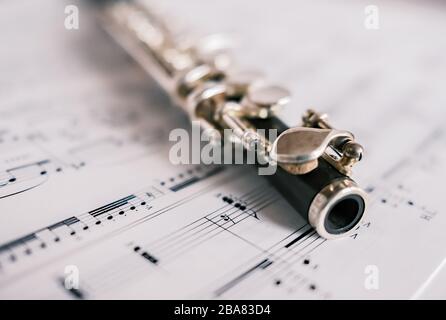 6 Close up and selective focus on a classic wooden flute on a background of unidentifiable sheet music Stock Photo