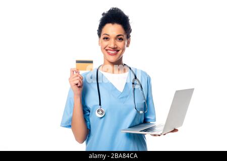 African american nurse with stethoscope holding laptop and showing credit card isolated on white Stock Photo