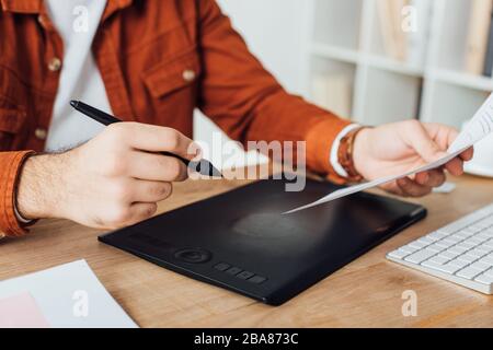 Cropped view of ux designer using graphics tablet while planning user experience design at table in office Stock Photo