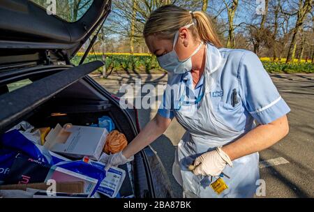 An NHS nurse collects more dressings from her car as she does a home visit in Sefton Park, Liverpool after Prime Minister Boris Johnson has put the UK in lockdown to help curb the spread of the coronavirus. PA Photo. Picture date: Thursday March 26, 2020. The UK's coronavirus death toll reached 463 on Wednesday. See PA story HEALTH Coronavirus. Photo credit should read: Peter Byrne/PA Wire Stock Photo