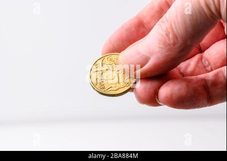 Australian Dollar coin reverse side in human hand for payment on white background with copy space Stock Photo