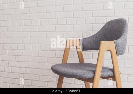 Modern grey chair with white brick walls on background Stock Photo