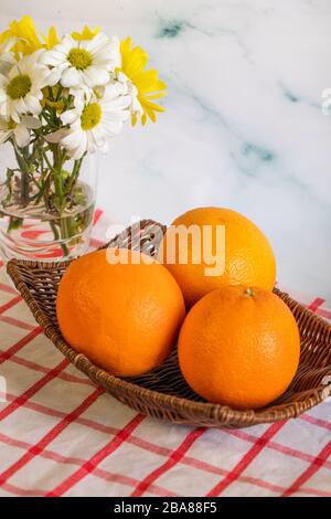 Oranges in a platter on the checked tablecloth Stock Photo