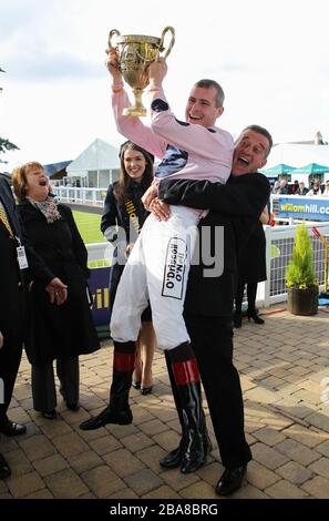 Captain Ramius jockey Pat Smullen holds aloft The William Hill Ayr Gold Cup as he is lifted up by the winning trainer Kevin Ryan Stock Photo