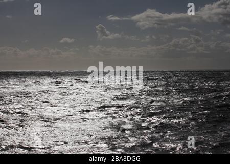 Shimmering silver sea stretching to the horizon Stock Photo
