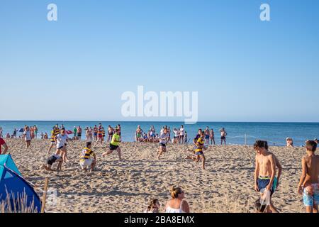 Youths playing rugby on the beach in Denia Costa Blanca Spain Stock Photo