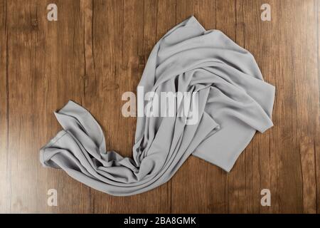 Grey textured shawl on a wooden table Stock Photo