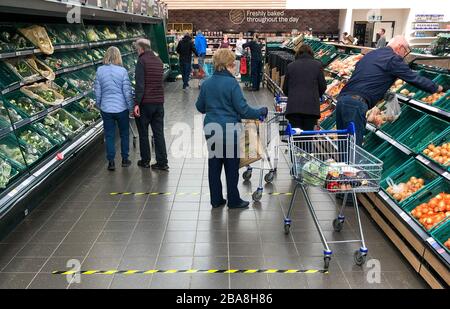 Tape marks out 2 metre sections on the floor to implement social distancing measures at a Tesco store in Peterborough, after Prime Minister Boris Johnson has put the UK in lockdown to help curb the spread of the coronavirus. Stock Photo