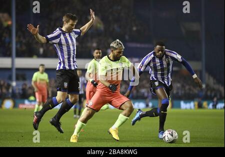 Manchester City's Sergio Aguero (centre) takes on Sheffield Wednesday's Dominic Iorfa (right) and Julian Borner Stock Photo