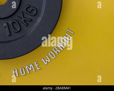 Home workout and a barbell weight isolated on yellow background Stock Photo