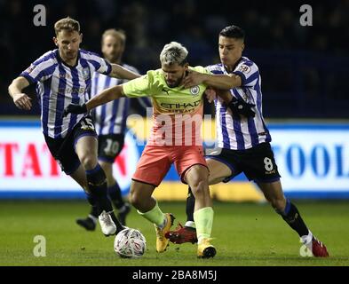 Manchester City's Sergio Aguero (centre) and Sheffield Wednesday's Joey Pelupessy (right) battle for the ball Stock Photo