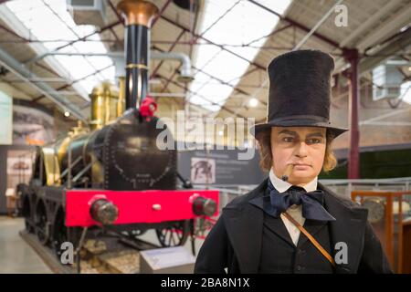 A life-size model of Isambard Kingdom Brunel, famous Victorian entrepreneur and engineer in front of a replica of one of his first steam locomotives o Stock Photo