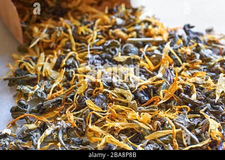 Herbal tea closeup. Multi coloured dried herbal tea leaves and brown kraft paper bag with selective focus. Stock Photo