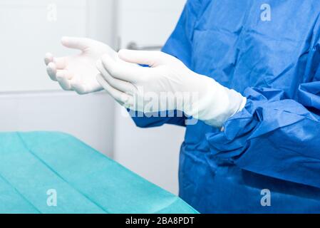 Covid-19. Doctor puts on protective gloves. Personal protective equipment in the fight against Coronavirus disease . Stock Photo