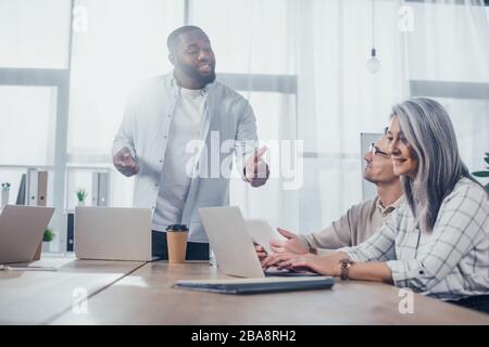 african american businessman talking with colleagues during meeting in creative agency Stock Photo