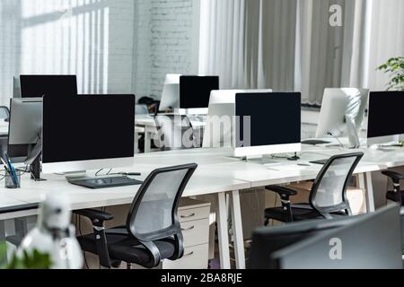 modern open space office with computer monitors on white desks Stock Photo