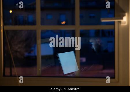 Person working at night with the computer from home, reflection of the window Stock Photo