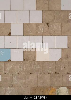 Old tiles and textures on decaying house wall Stock Photo