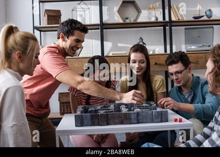 KYIV, UKRAINE - JANUARY 27, 2020: cheerful young friends playing labyrinth board game at home Stock Photo