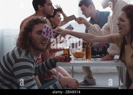 KYIV, UKRAINE - JANUARY 27, 2020: aggressive friends quarreling and screaming while holding lotto cards Stock Photo