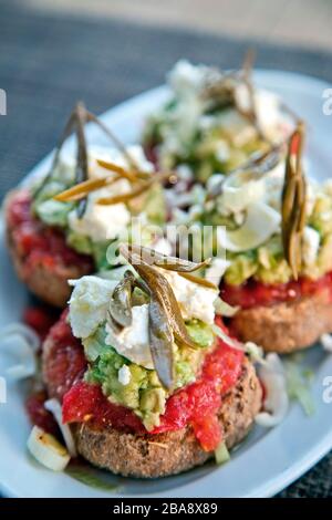 Dakos salad (also known as 'koukouvagia' or 'ladouristo'), typical traditional Cretan plate - meze. Stock Photo