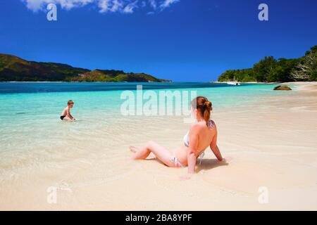Frau liegt im Bikini am Strand, beobachtet ihren Jungen,  menschenleer, MR: Yes, 30,35, 7, Jahre Stock Photo