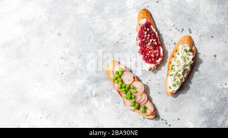 Assorted bruschetta or tapas set with different savory and sweet topping on gray concrete background.Flat lay of italian appetizer open toasts Stock Photo