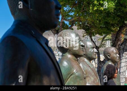 Black girl standing with the statues of the country's four Nobel Peace Prize winners at Nobel Square, V&A Waterfront, Cape Town, South Africa Stock Photo