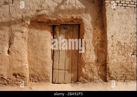 Facade with wooden door. Old earth house in ancient, Uygur quarter of Kashgar, Xinjiang, China Stock Photo