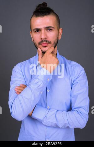 Portrait of handsome bearded Turkish businessman thinking Stock Photo