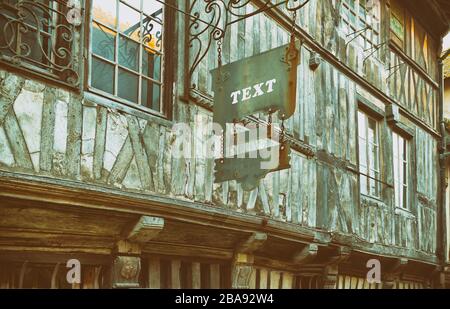 Hanging sign advertising panel on frontage of an old European wooden ...