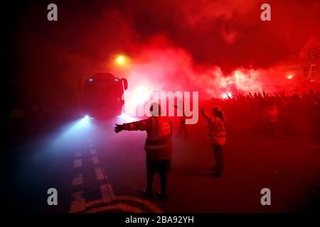 The Liverpool bus arrives ahead of the match as fans let off flares outside The Arkles pub in Liverpool Stock Photo