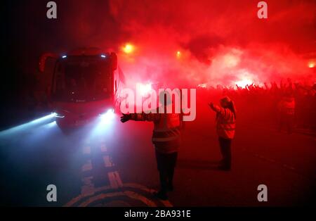 The Liverpool bus arrives ahead of the match as fans let off flares outside The Arkles pub in Liverpool Stock Photo