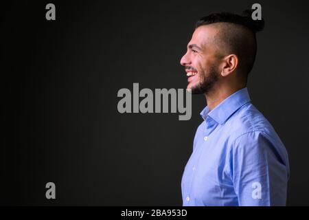 Closeup profile view of happy bearded Turkish businessman smiling Stock Photo