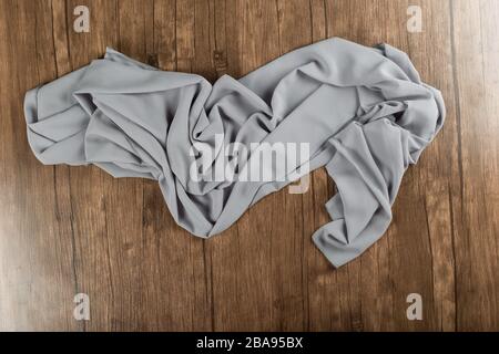 Grey textured tablecloth or tissue isolated on wooden table Stock Photo