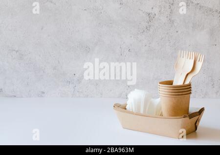 Eco-friendly biodegradable cardboard or paper dishes. Zero waste recycling concept. Catering and street fast food paper cups, plates and wooden forks. Stock Photo