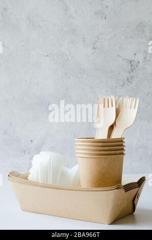 Eco-friendly biodegradable cardboard or paper dishes. Zero waste recycling concept. Catering and street fast food paper cups, plates and wooden forks. Stock Photo