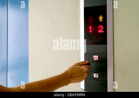 Pressing the lift buttons with key to stay safe from Coronavirus Stock Photo
