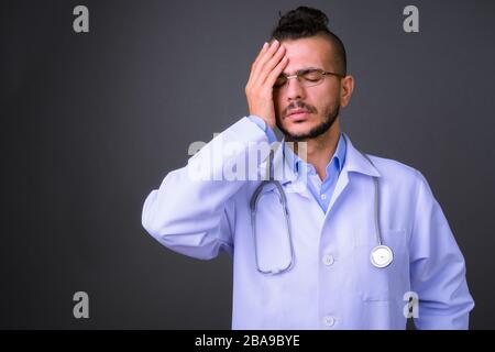 Portrait of stressed bearded Turkish man doctor having headache Stock Photo