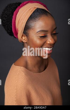 Portrait of a young black woman wearing a headband and laughing. Stock Photo