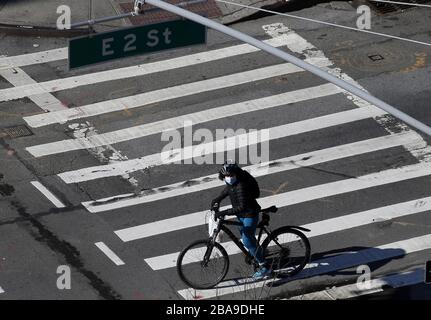 New York, United States. 26th Mar, 2020. A woman wearing a protective face mask and riding a bicycle rests in a crosswalk in New York City on Thursday, March 26, 2020. Thousands of new COVID-19 infections are being reported in New York daily and as of Thursday morning there have been approximately 33,000 confirmed cases of the coronavirus in the state, including more than 20,000 in New York City alone. Photo by John Angelillo/UPI Credit: UPI/Alamy Live News Stock Photo