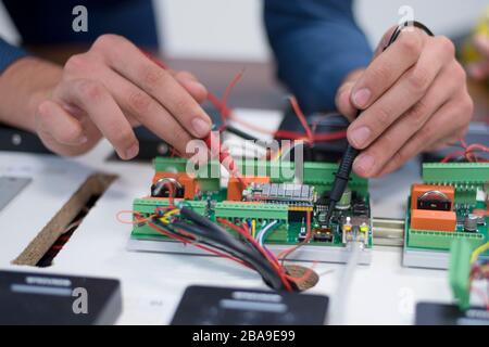 Two young handsome engineers working on electronics components.Tech tests electronic equipment in service center. Technologically Advanced Scientific Stock Photo